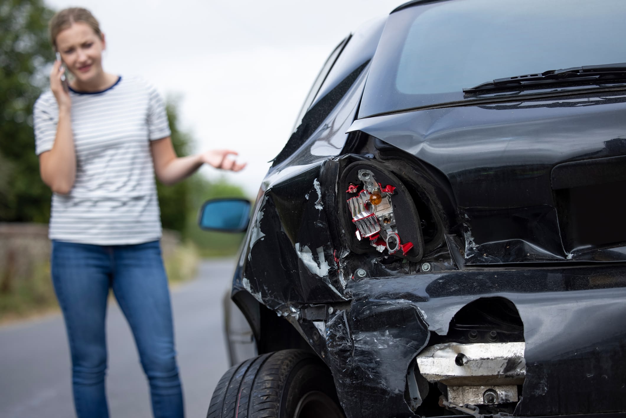 Unhappy Female Driver With Damaged Car After Accident Calling Insurance Company On Mobile Phone Woman Making Call After Car Accident
