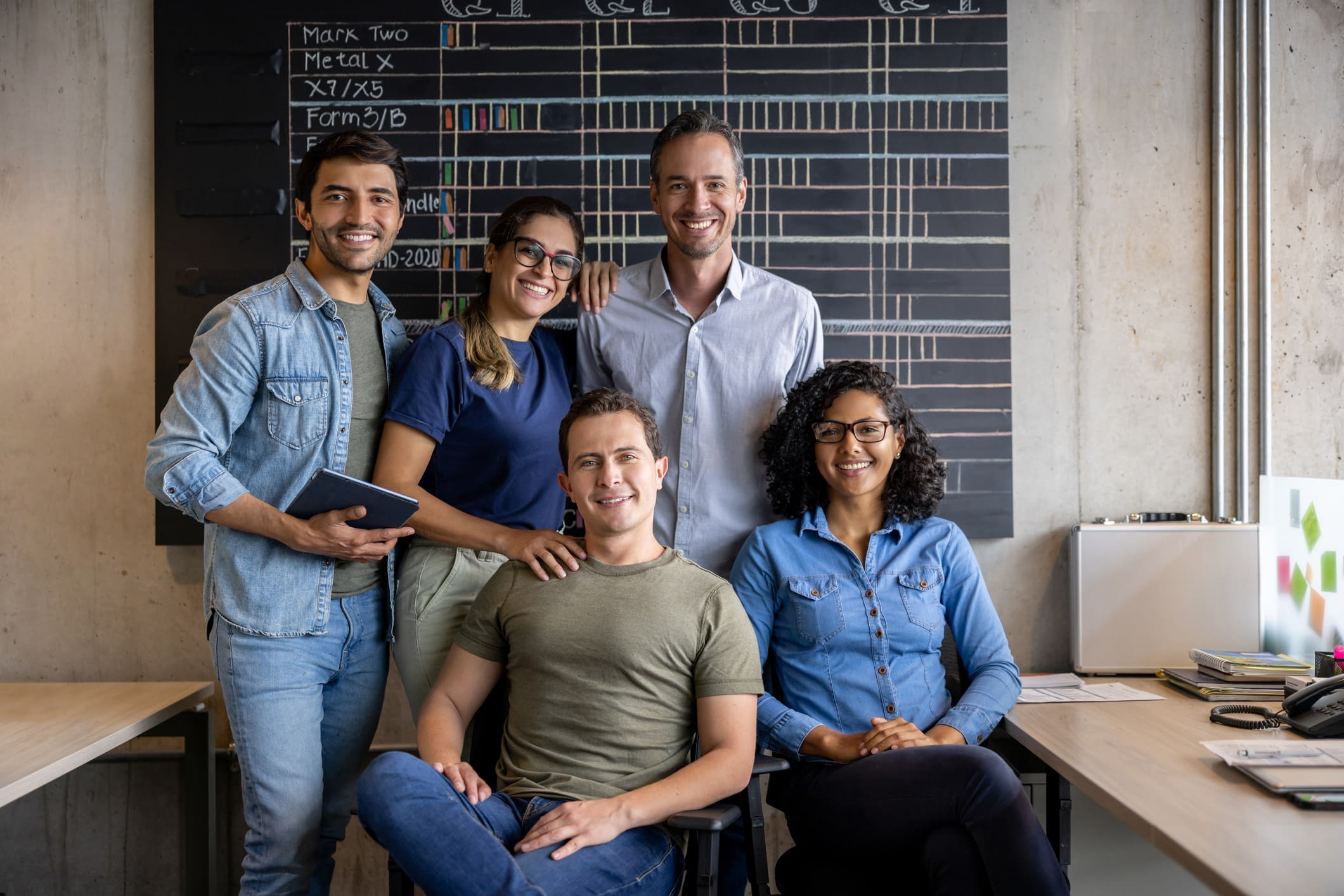 Group of coworkers looking happy working together at the office A group of professional Latinx people.