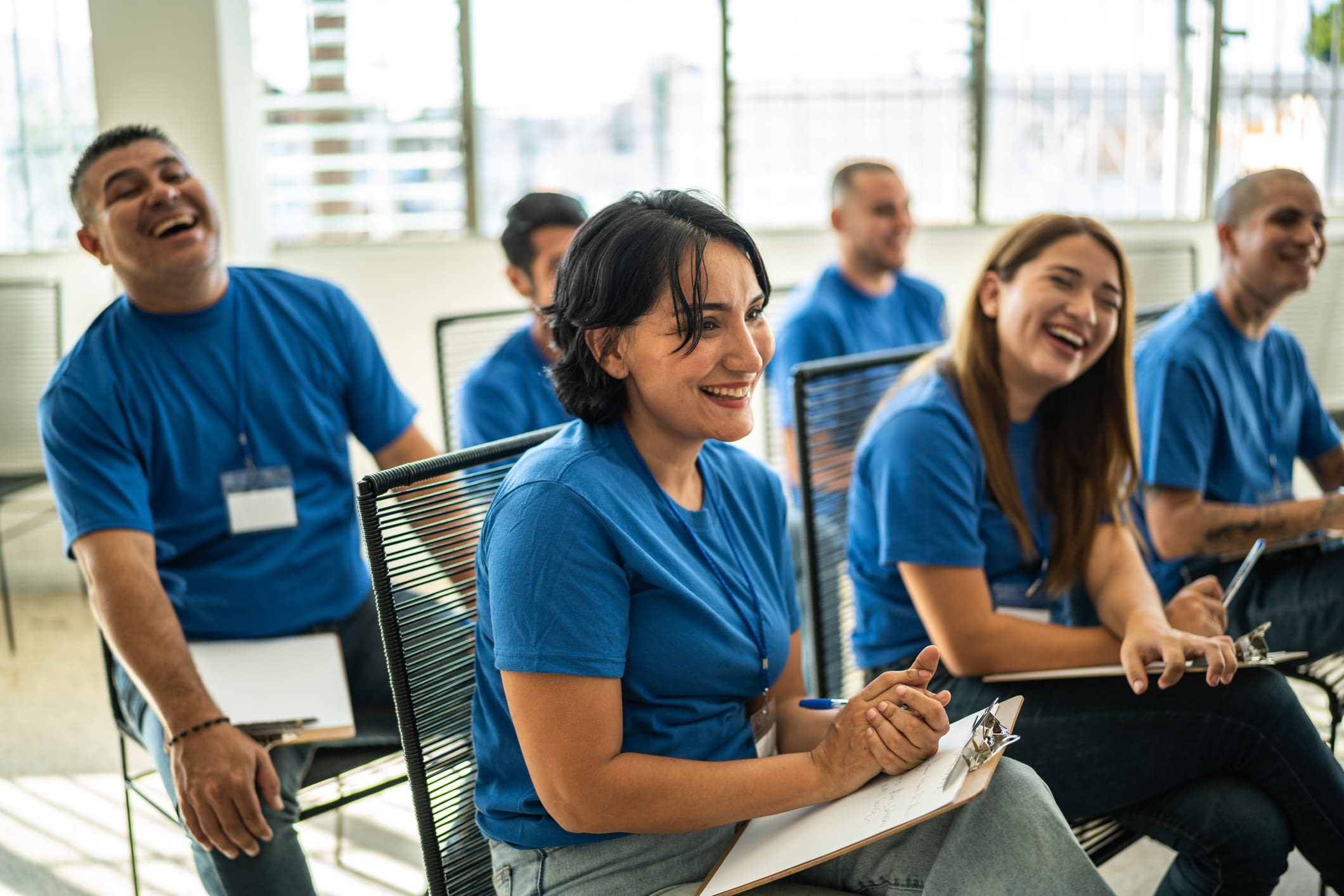 Volunteers paying attention and smiling at a presentation