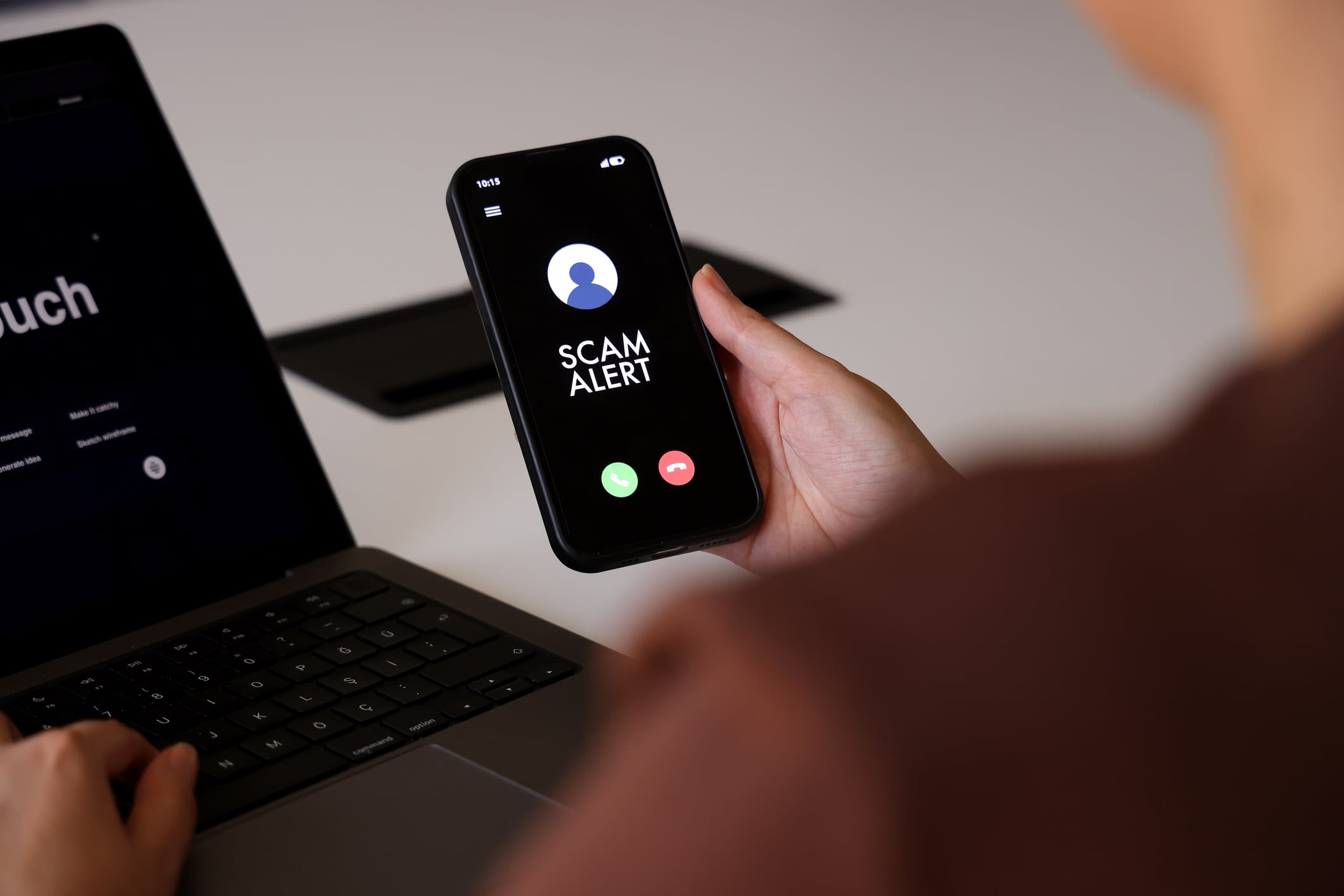 Scam Alert Notification on Smartphone Screen During Incoming Call Mobile phone with a scam alert on the screen.