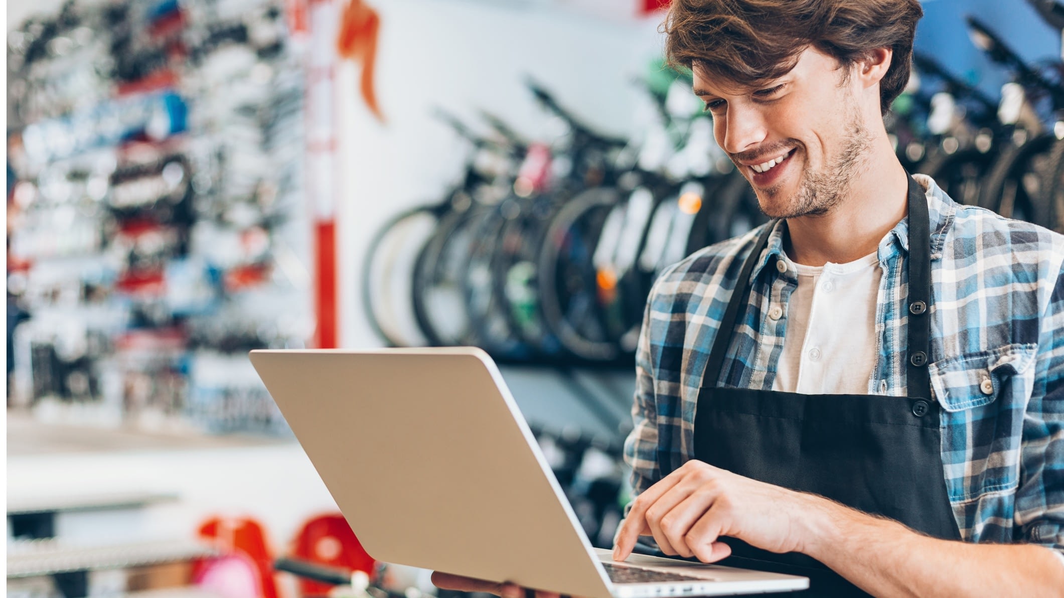 Man in his bike shop on the laptop