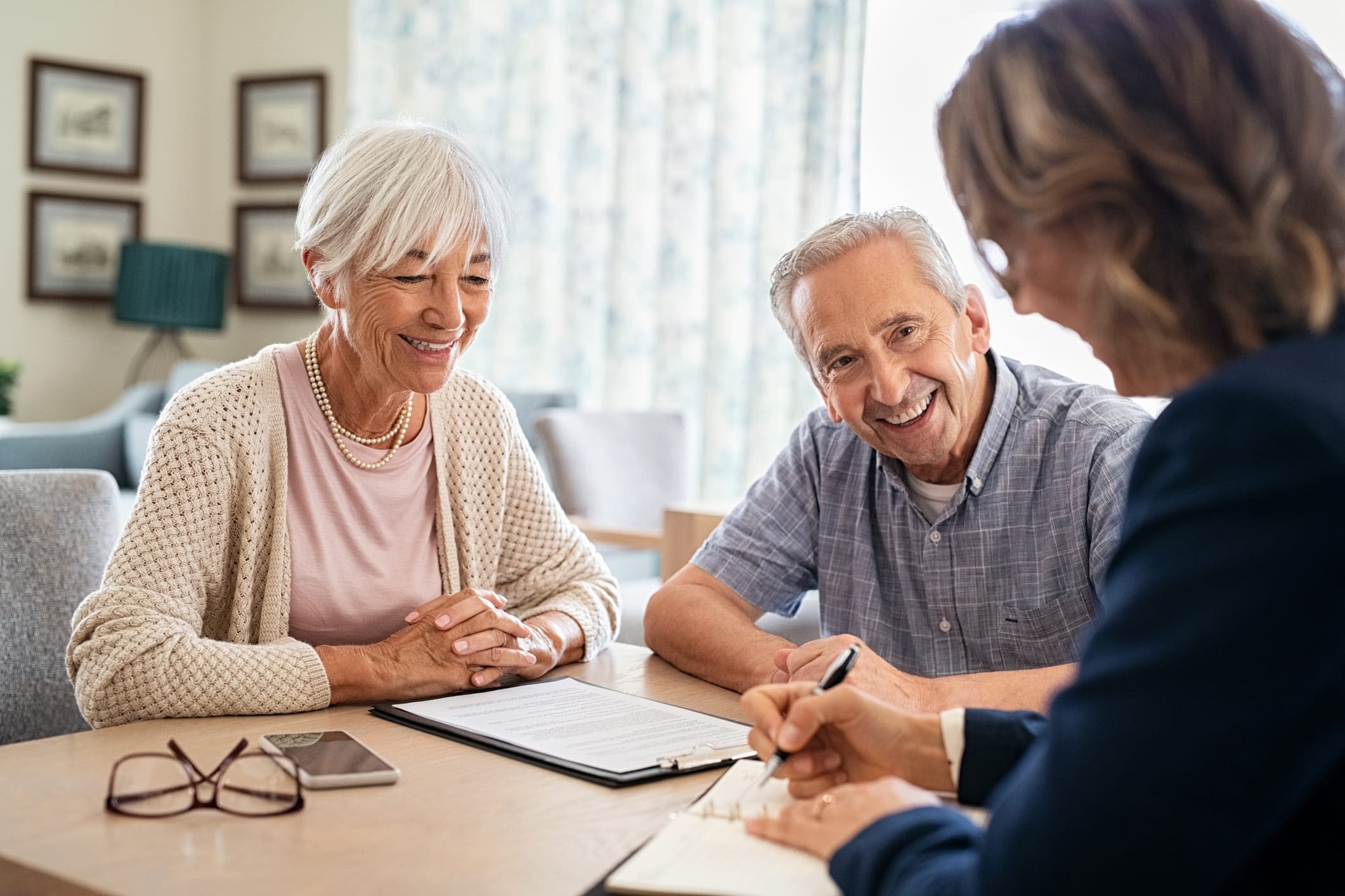 GettyImages-1316202262 Happy Senior Couple Talking to Consultant