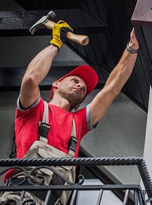 Contractor hammering a gutter
