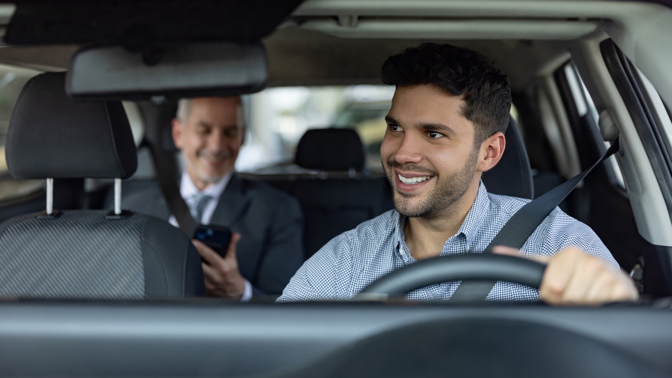 Rideshare driver smiling at passenger