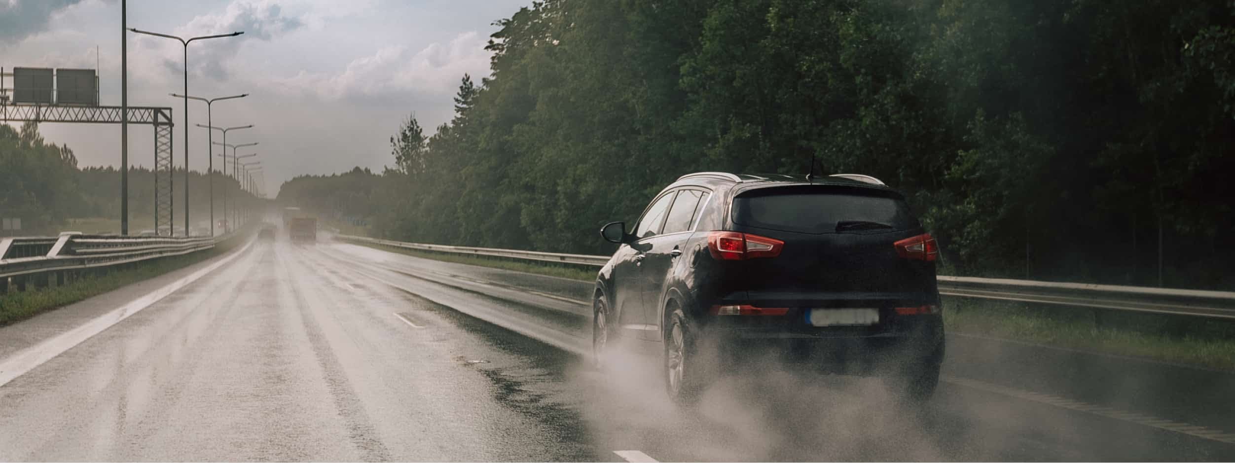 hero-driveway-car-driving-in-rain