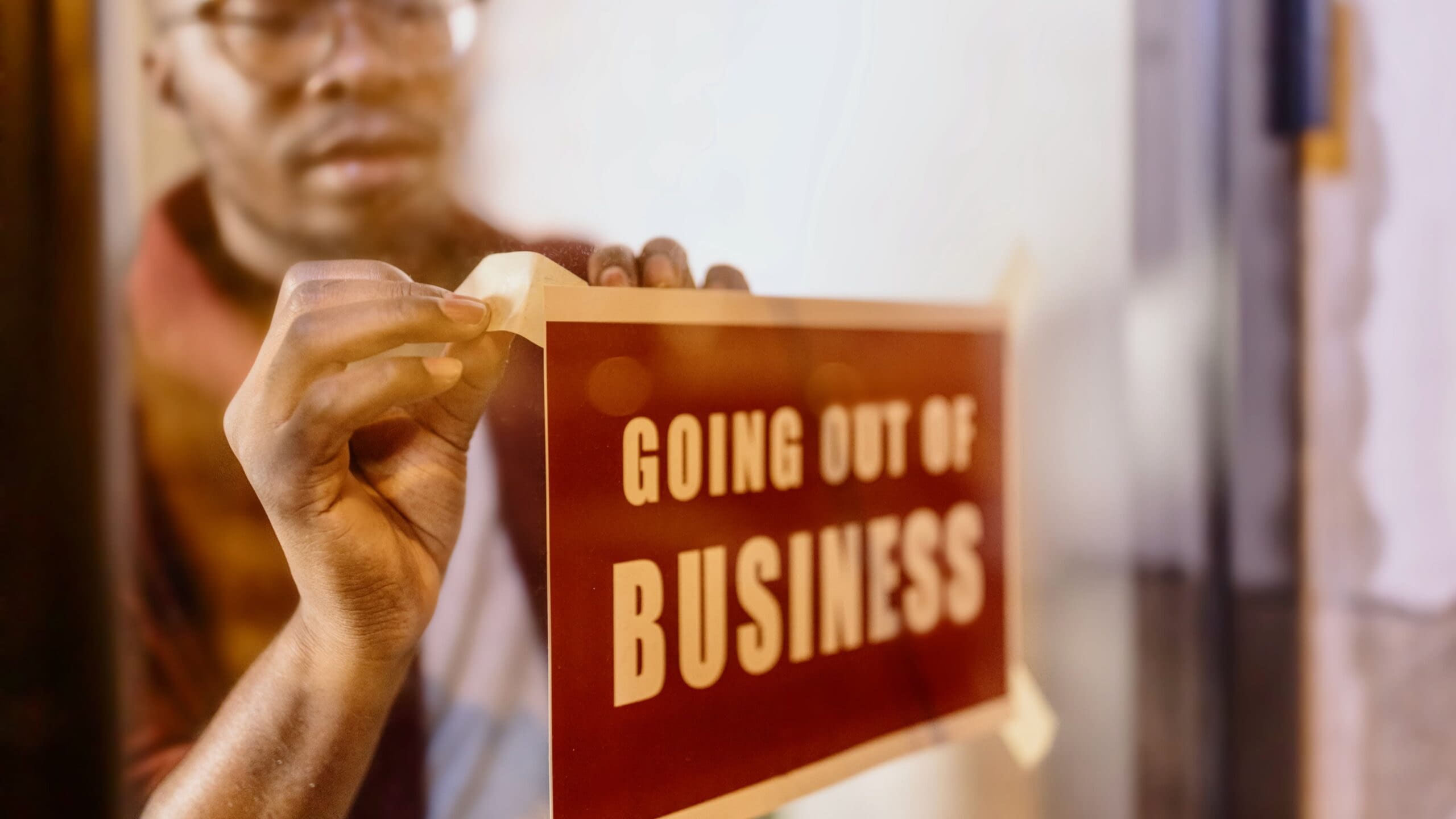 August 13th blog African-American business owner putting up a sign in the window saying