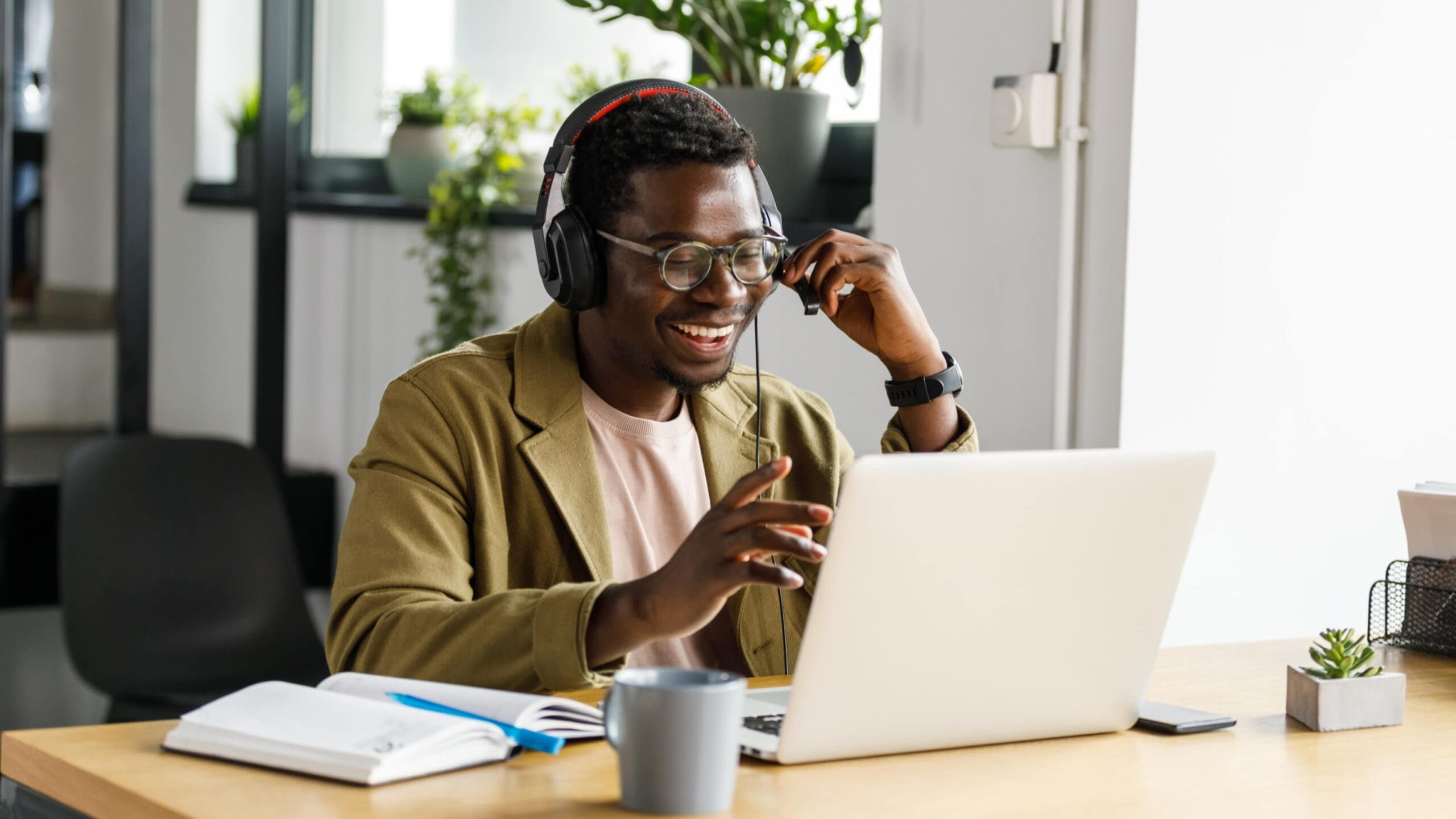 August 28th blog happy young African-American man working at his laptop with headset on