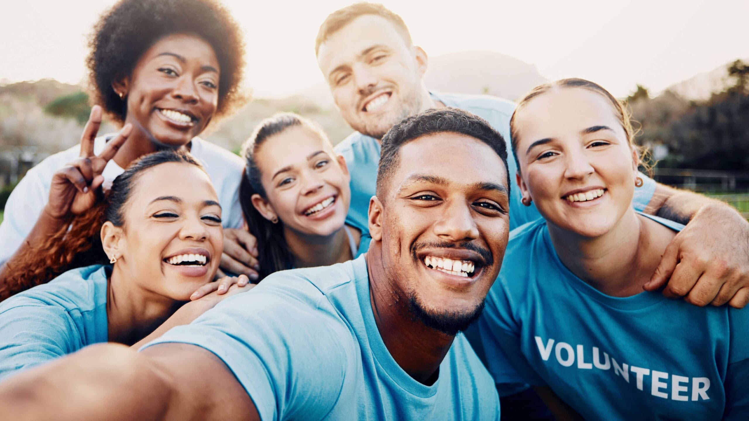 diverse group of people smiling doing volunteer work