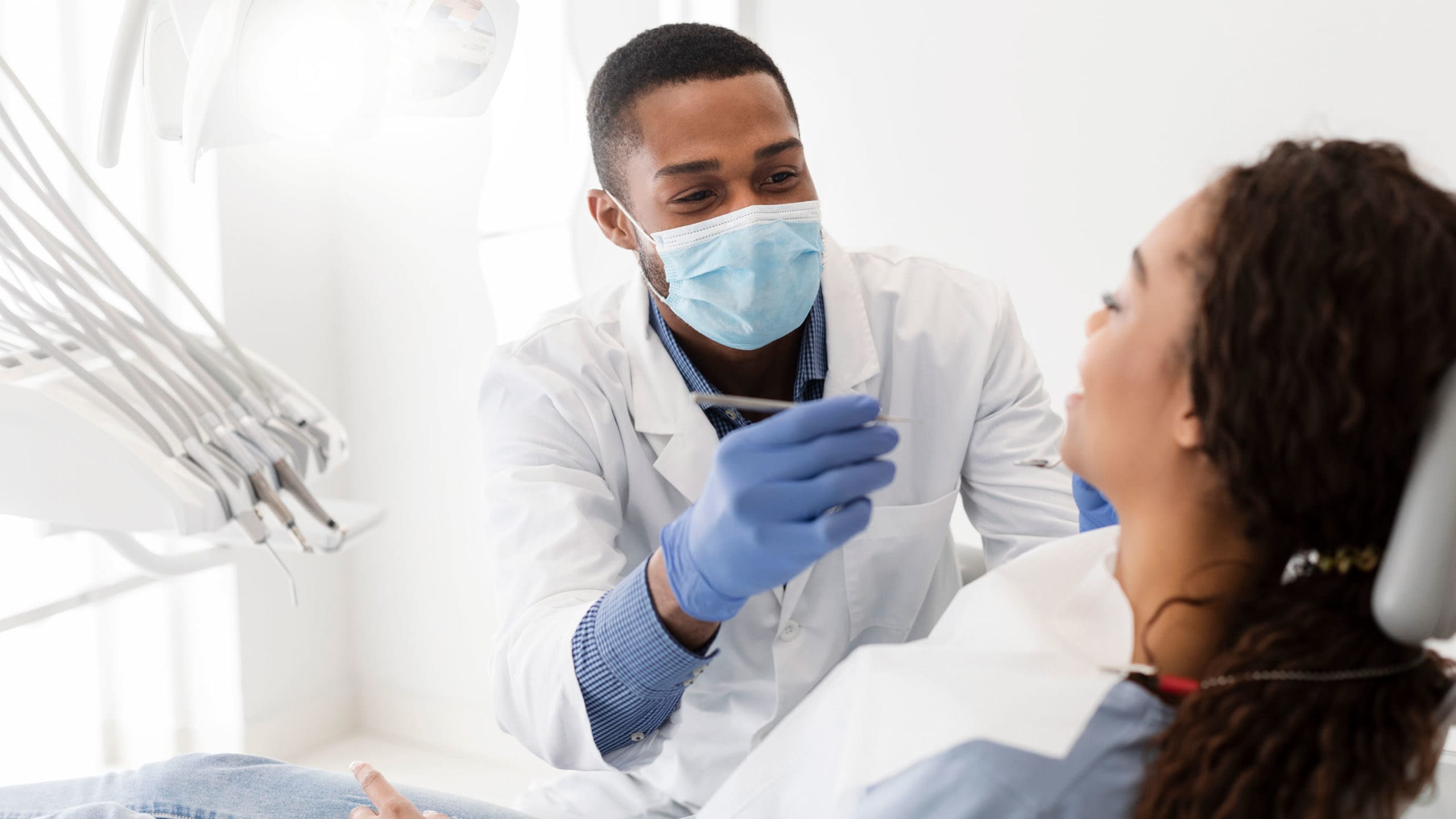 Friendly dentist working on patient's teeth.
