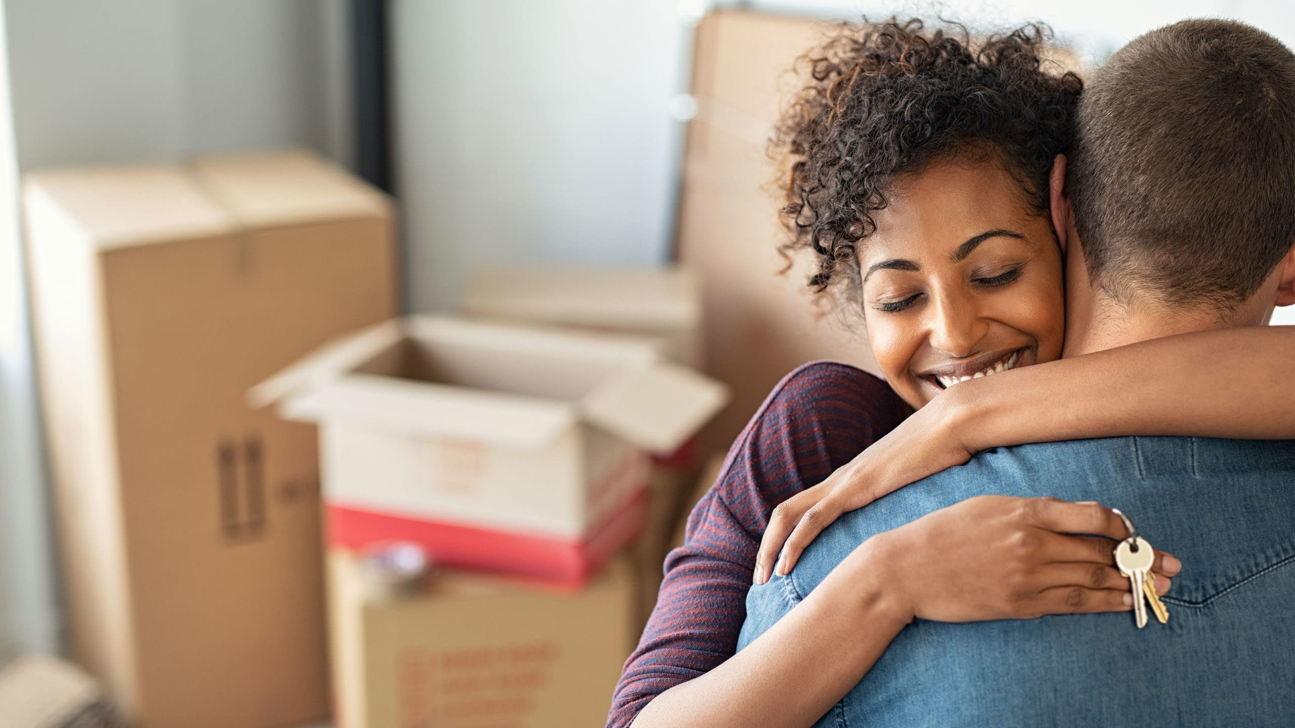 Happy couple embracing each other celebrating the purchase of their new home.