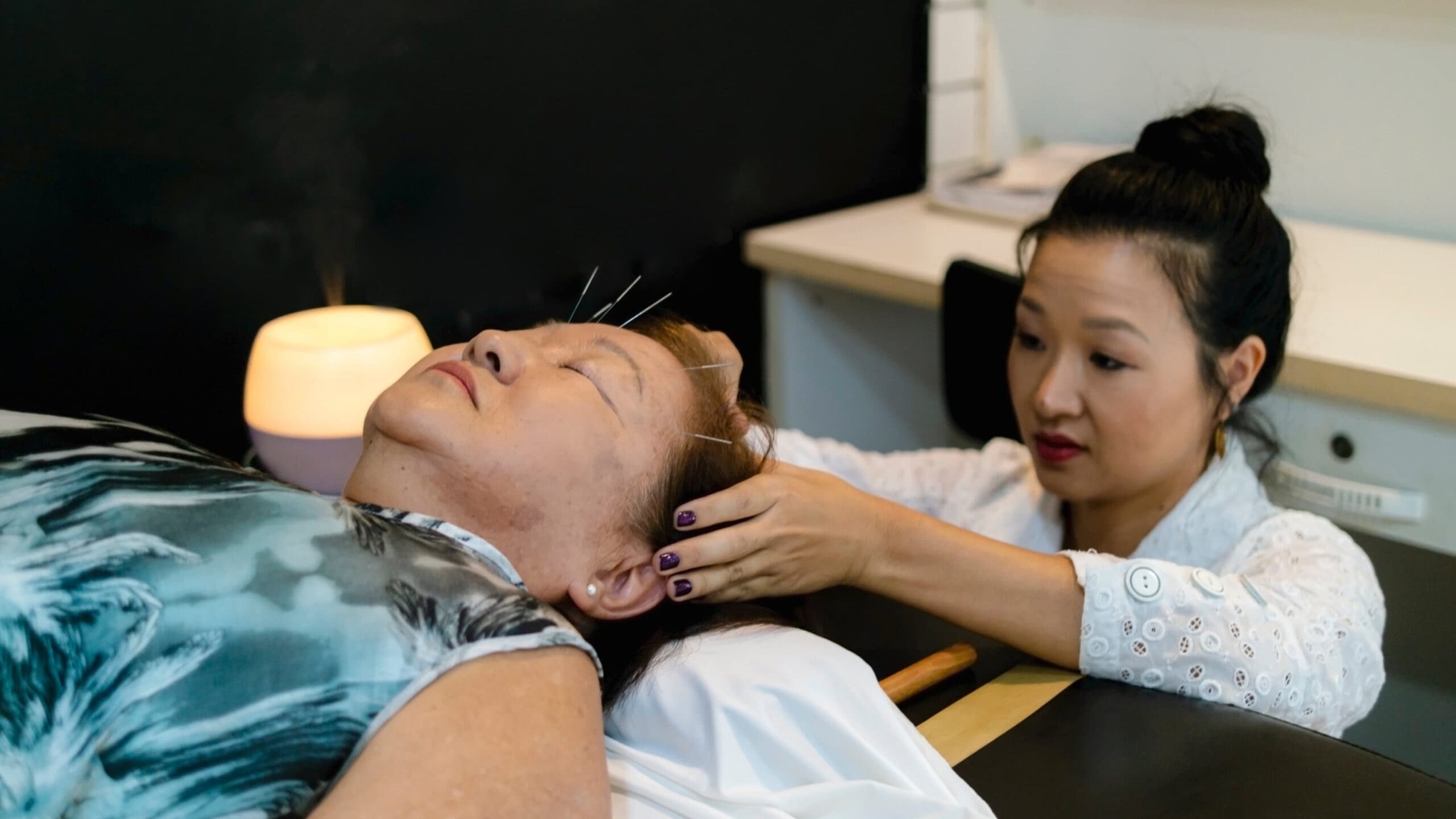 7-6 Blog Image senior aged woman receiving acupuncture treatment in her forehead