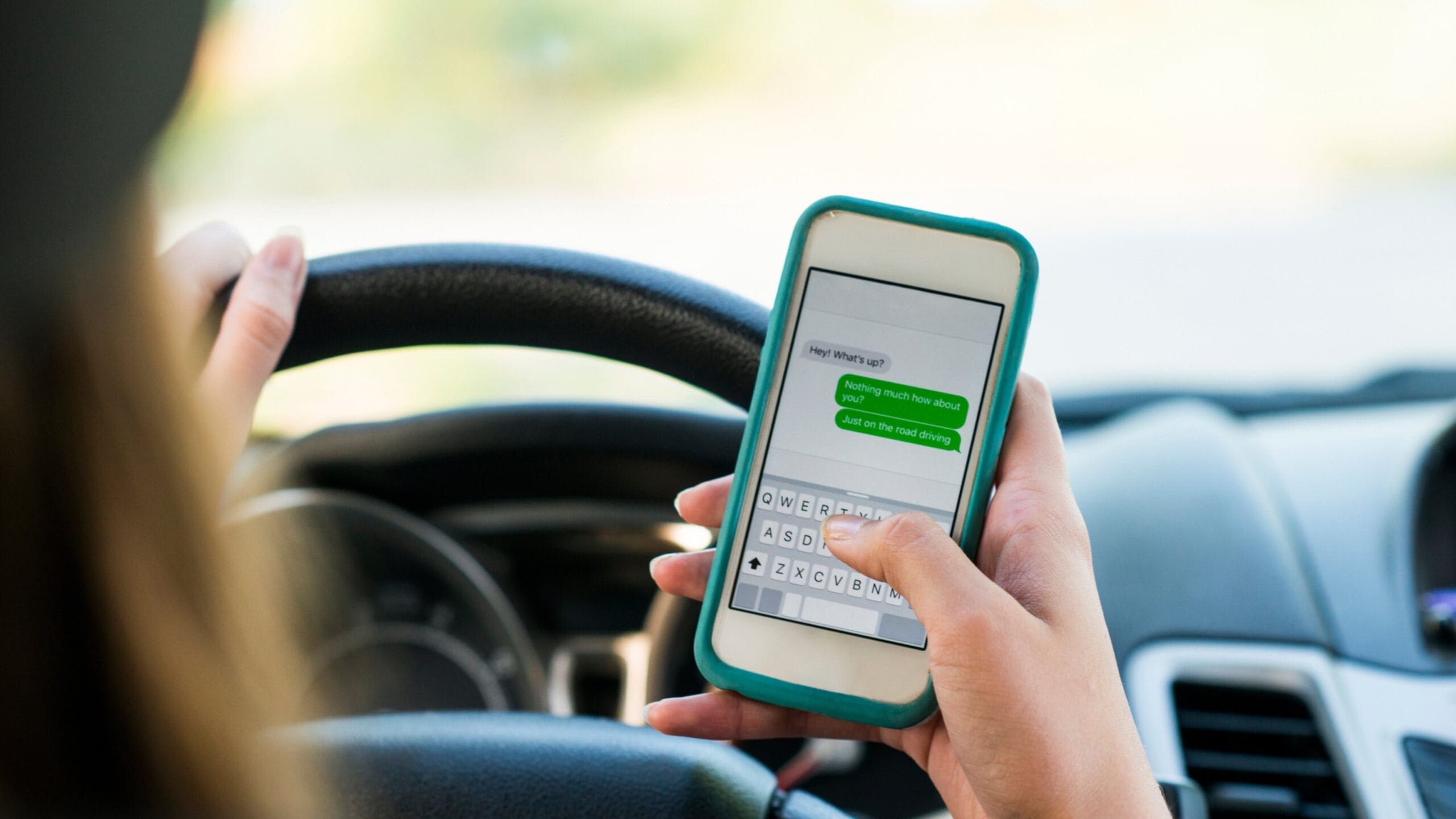 woman distracted driving texting on cell phone