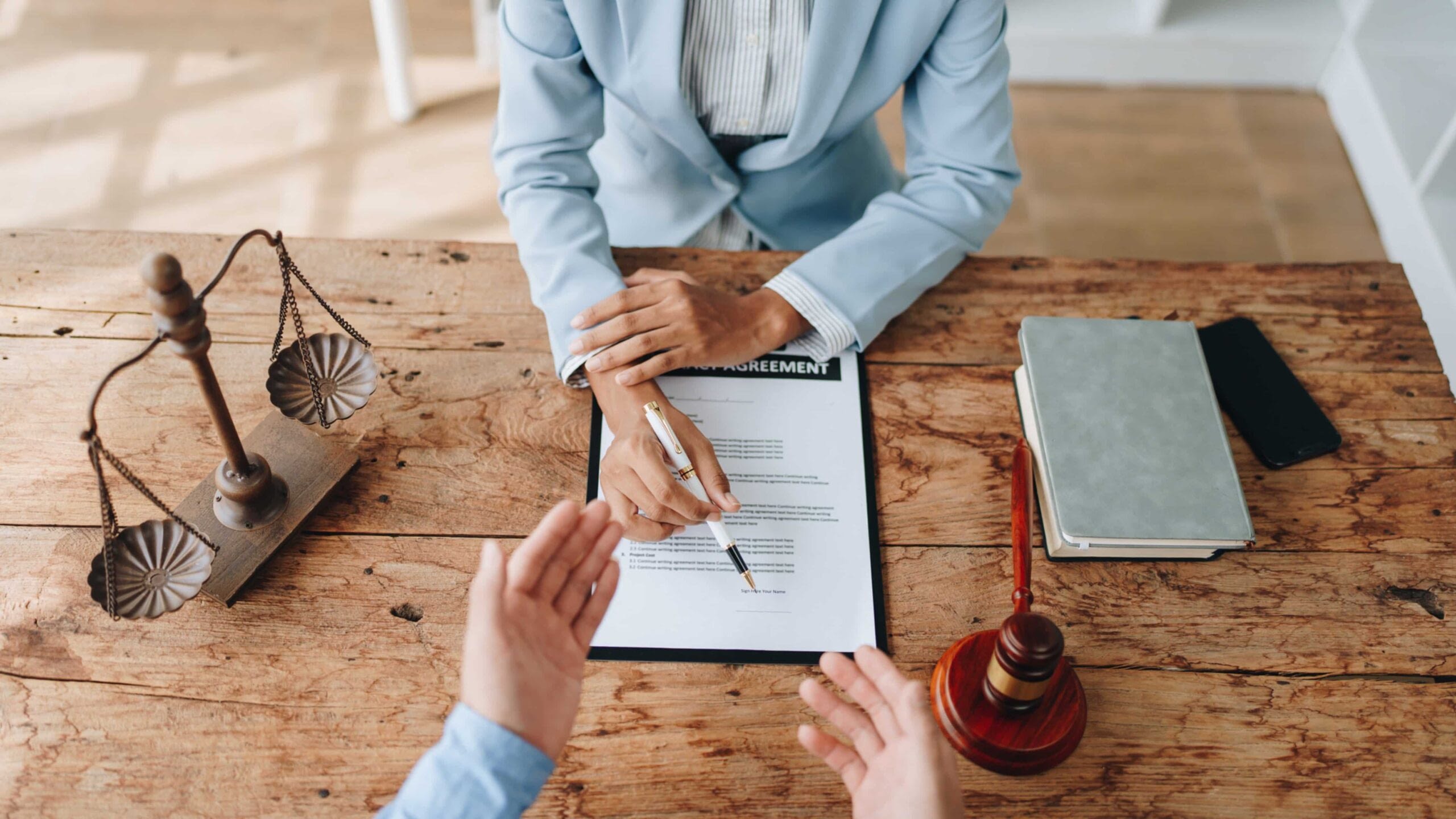 woman in suit explaining policy agreement with pen