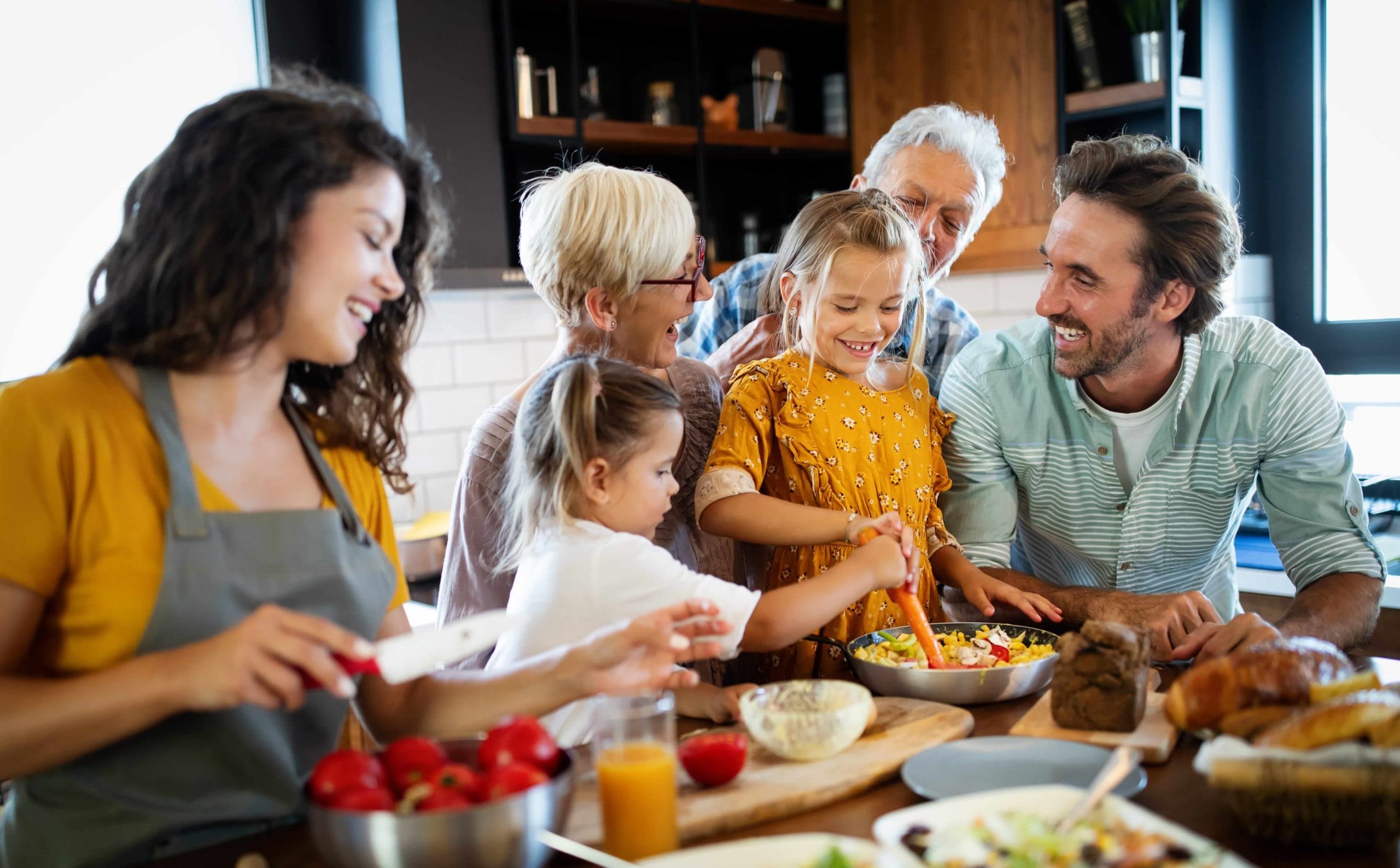 GettyImages-1199847976 (1) family cooking meal together