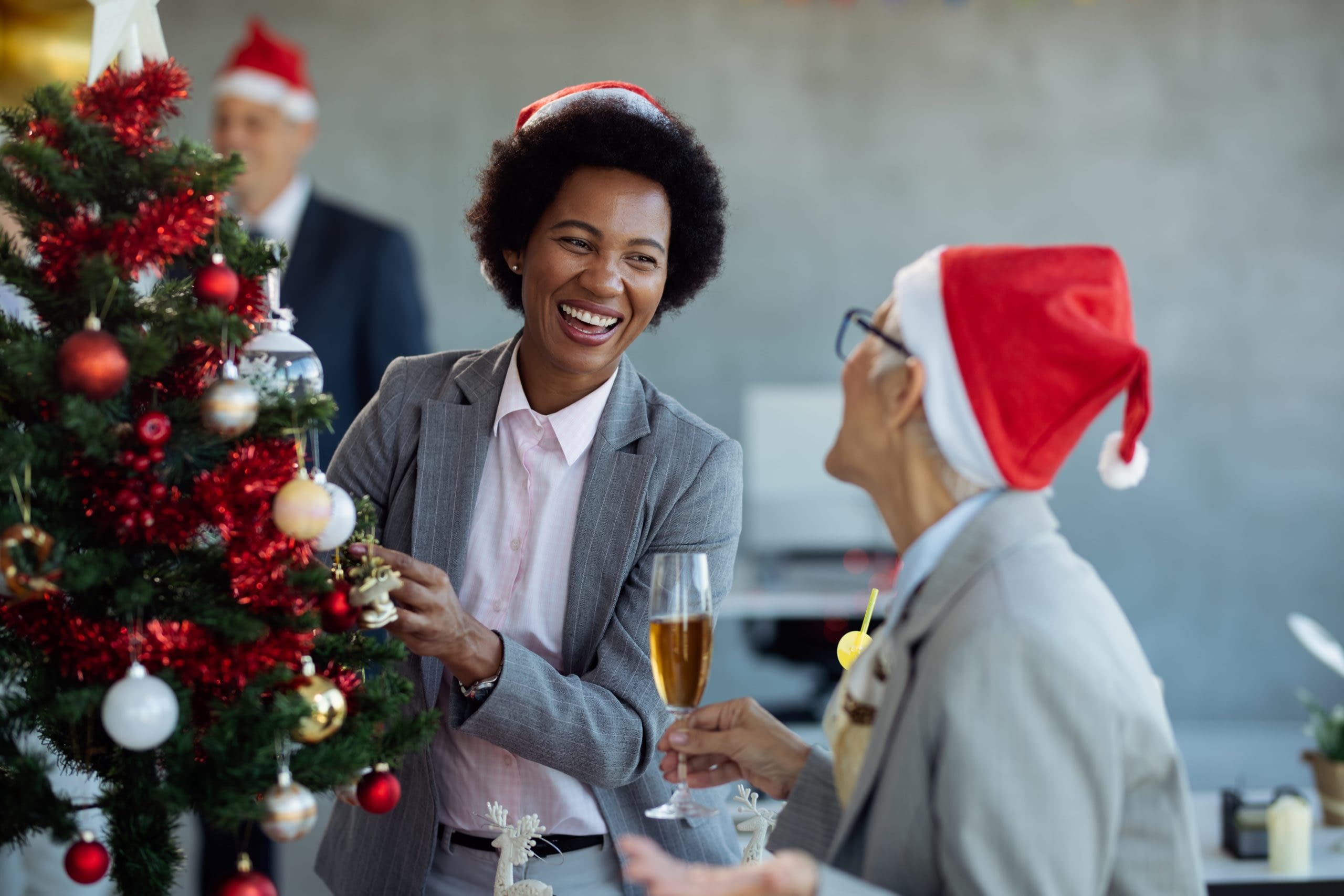 GettyImages-1282891630 Happy Staff Decorating Christmas Tree