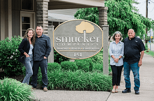 Tasha Heydinger, Chad Heydinger, Ralph Smucker, and Lisa Smucker standing next to Smicker Insurance Agency sign