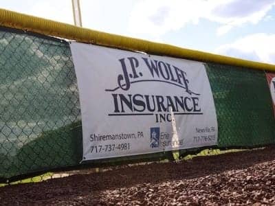 JP Wolfe Insurance banner at a baseball field