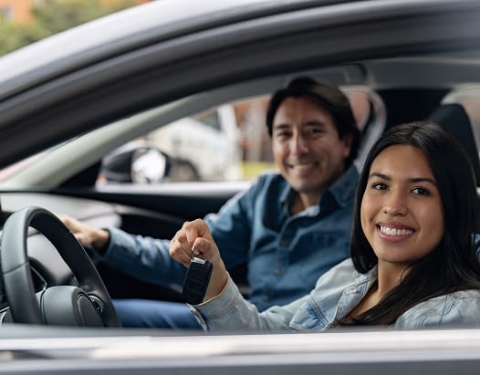 Young woman holding the keys to her new car