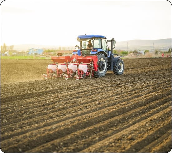 rear-view-of-farmer-planting-seeds-with-tractor