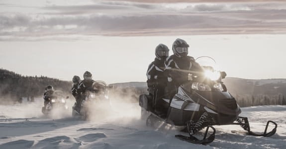 People Riding Snowmobile