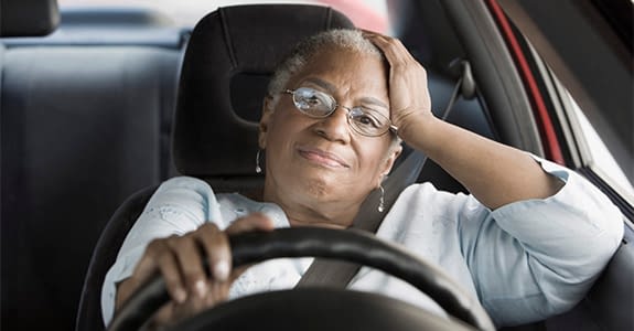 African woman driving car in traffic