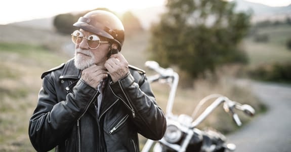 man_putting_on_motorcycle_helmet_575x300