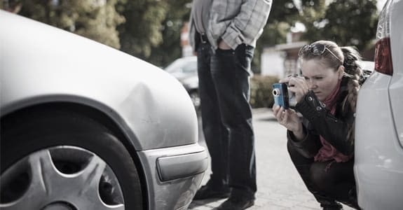 Person taking a picture of a car at wreck