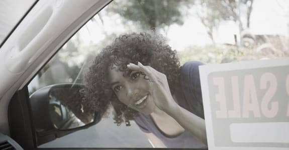 Excited Woman Looking Inside Used Car