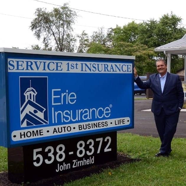 owner in front of sign