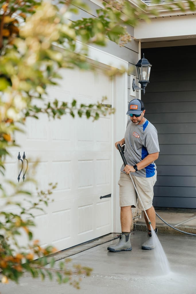 Man power-washing driveway