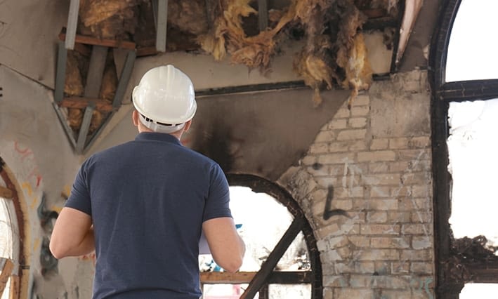 adjuster inspecting house