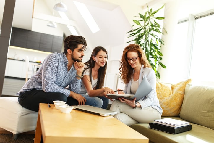 Young Couple Reviewing Documents With Consultant