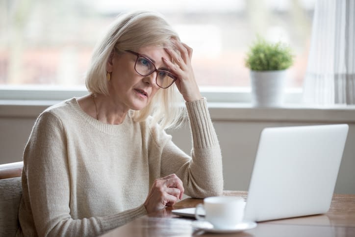 Confused mature woman thinking about online problem looking at laptop Confused Senior Woman Looking at Laptop