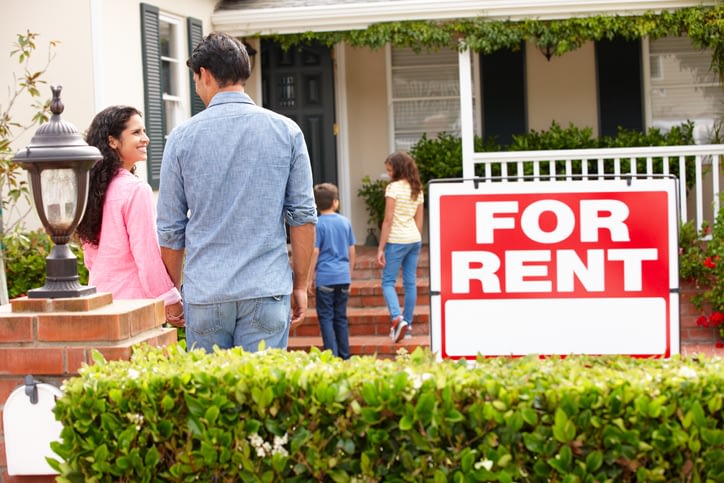 Smiling Hispanic Family Outside of Rental Home