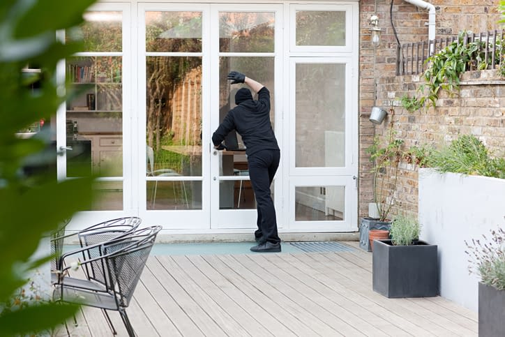 Burglar standing at patio door Burglar standing at patio door