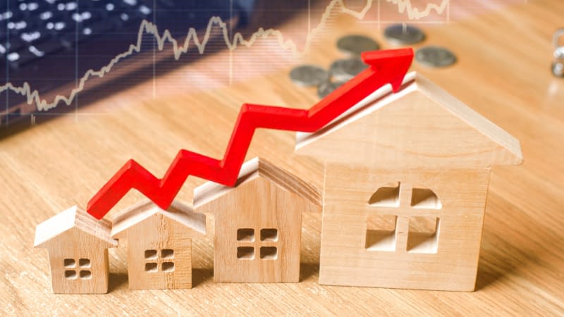 Home Insurance 101326 wooden block houses with a graphic red arrow above them