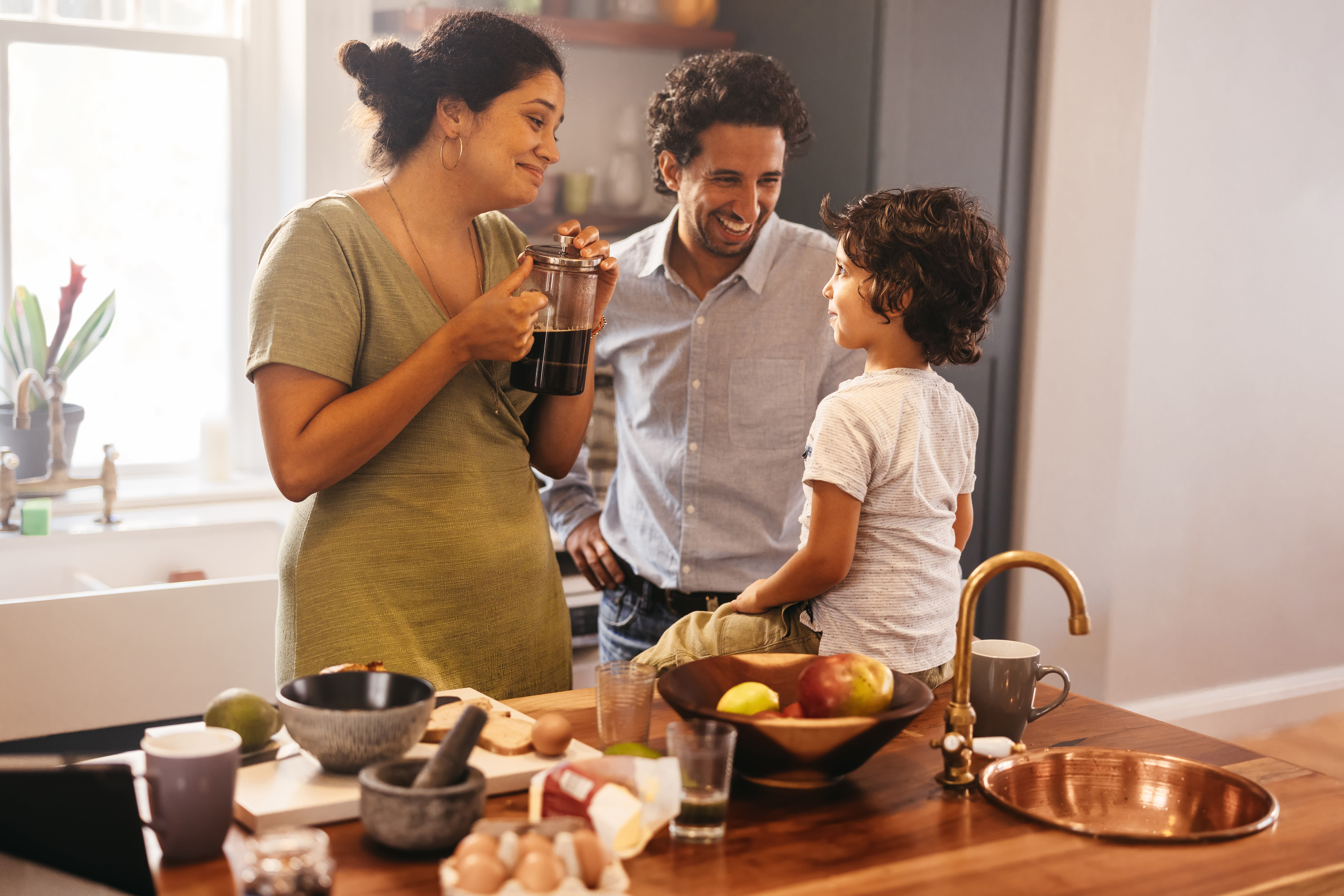 family of 3 in kitchen talking