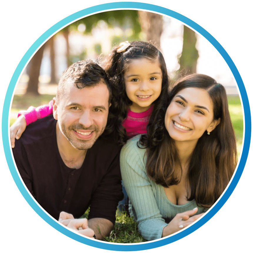 Smiling Family Lying On Grass At Park During Sunny Day