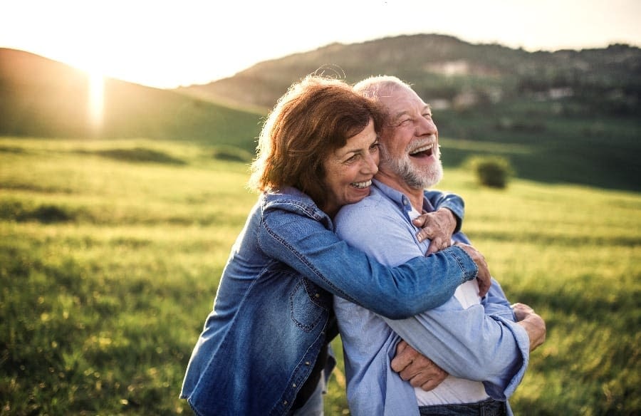 Senior couple hugging outside