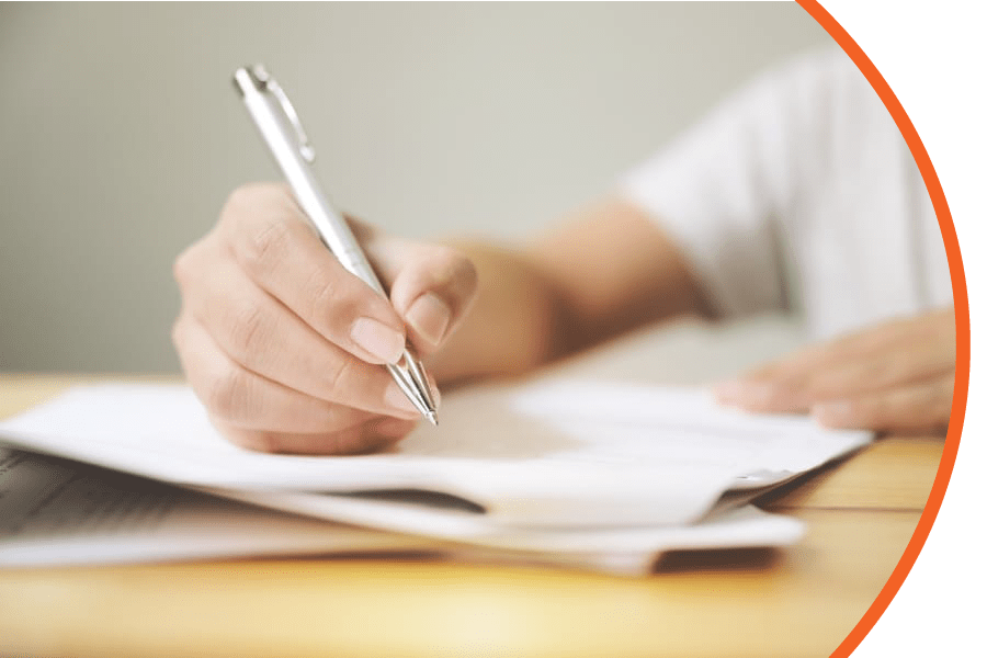 person holding silver pen over paperwork