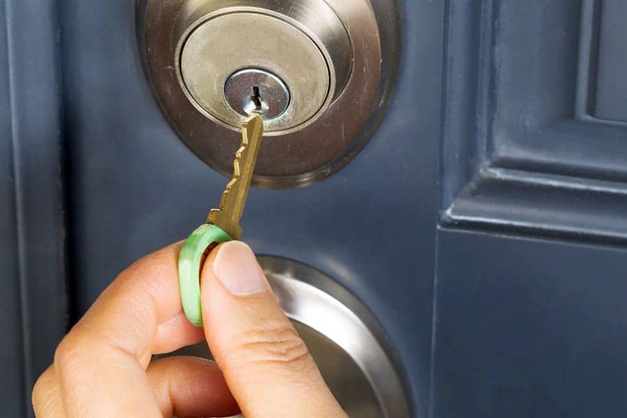 Person unlocking a door with a key