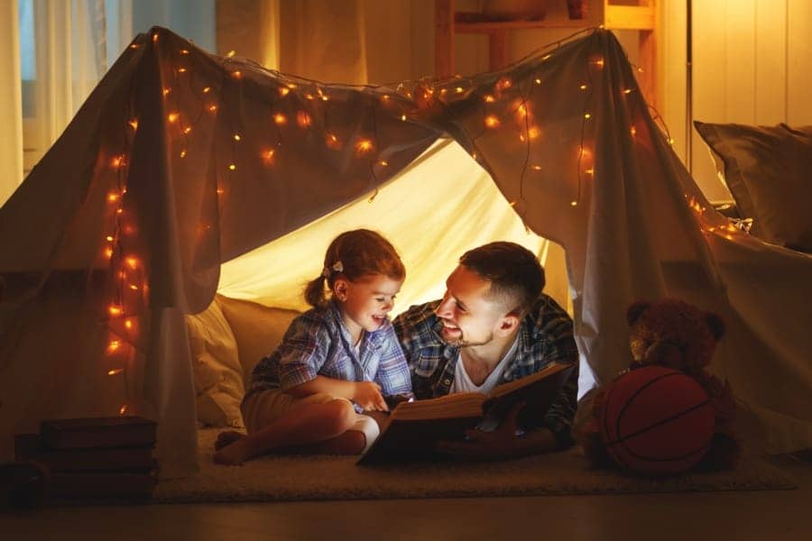 father reading his daughter a bed time story