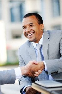 Professional Man Smiles as He Shakes his Business Partner's Hand