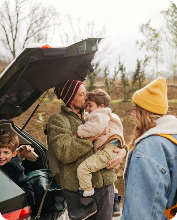 cheerful family packing up in the trunk of their car for an autumn adventure