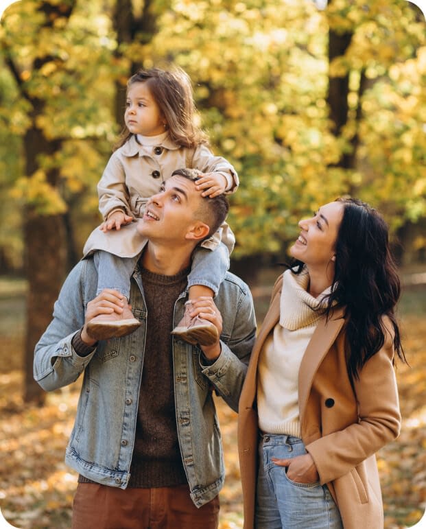 Happy young family spending time together in autumn park
