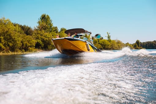 yellow boat soaring through the lake
