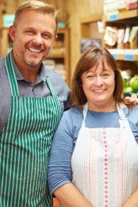 Male and Female Grocery Store Owners Stand in Food Aisles