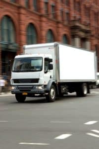 White Commercial Truck Driving Down the Road