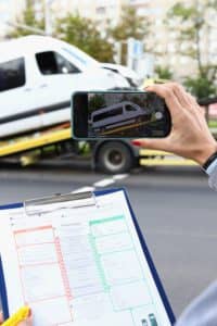 Individual taking photo of their commercial shuttle bus being towed away.